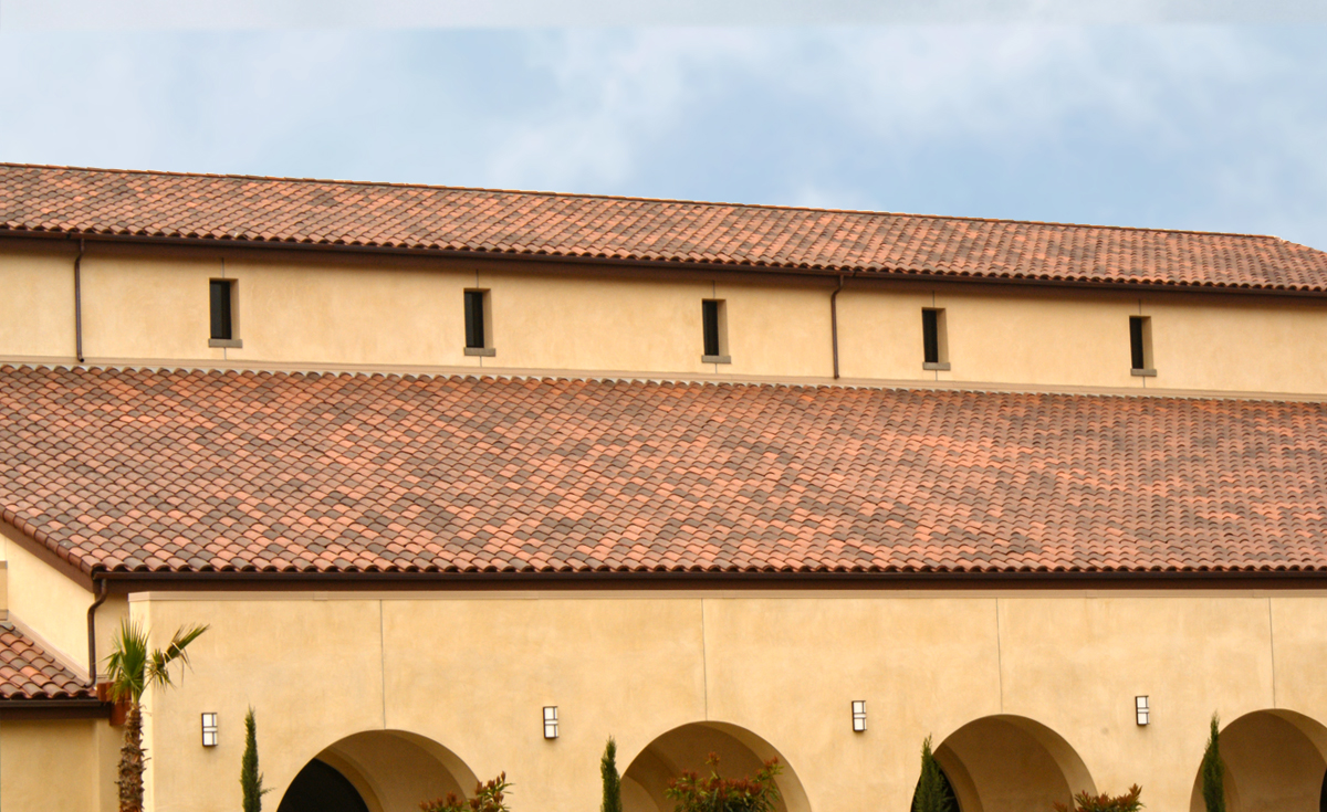 Roof detail of One Piece S Mission clay roof tile in B330-R Old Santa Barbara Blend with two piece eace line on Holy Trinity Catholic Church in Ladera Ranch, California