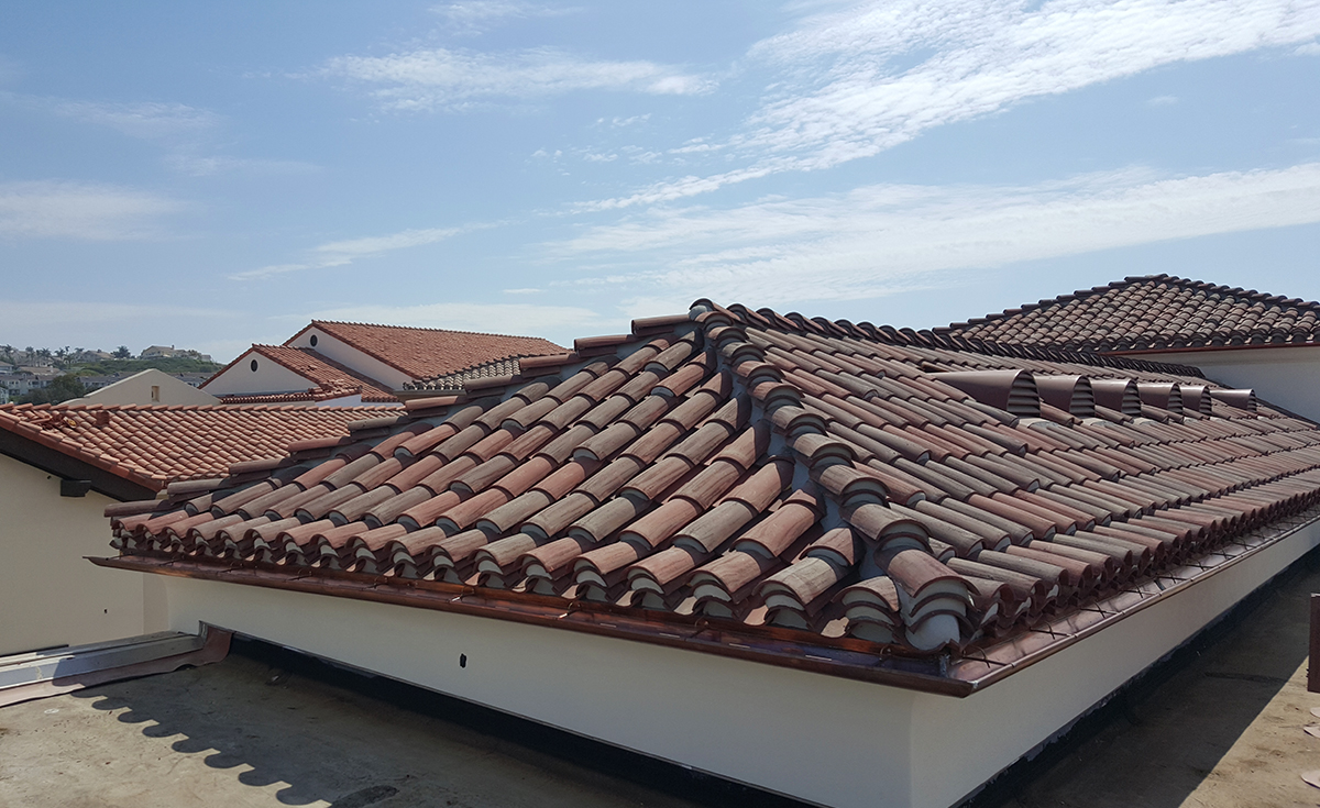 corona tapered mission two piece clay roof tile with mortar and boosting in various custom blends on rooftop of outlets at san clemente california.