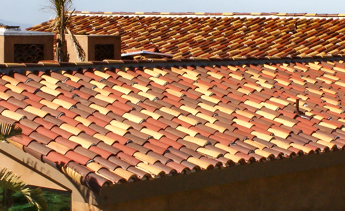 Detailed angle view of Serpentine installation of Classic "S" Mission clay roof tile with two piece eave line in 14.3% 2F43-SSC Villa Rosso Blend, 19% 2F43-SC Brick Red Sandcast, 7.4% 2F45-SSC Tierra Brown Blend, 26% 2F45-SC Tobacco Sandcast, and 33.3% CB46-SC Rustic Tuscan Blend on home in Ventura California.