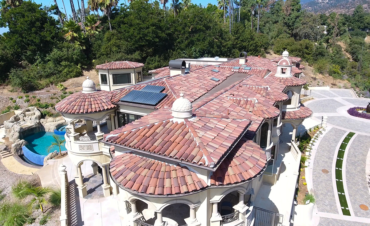 View of dome awnings and roof on custom mansion on a hilltop in Bradbury California featuring Classic Tapered two piece terra-cotta clay roof tile with turrets, domes, and dome awnings in custom color blend CB477.