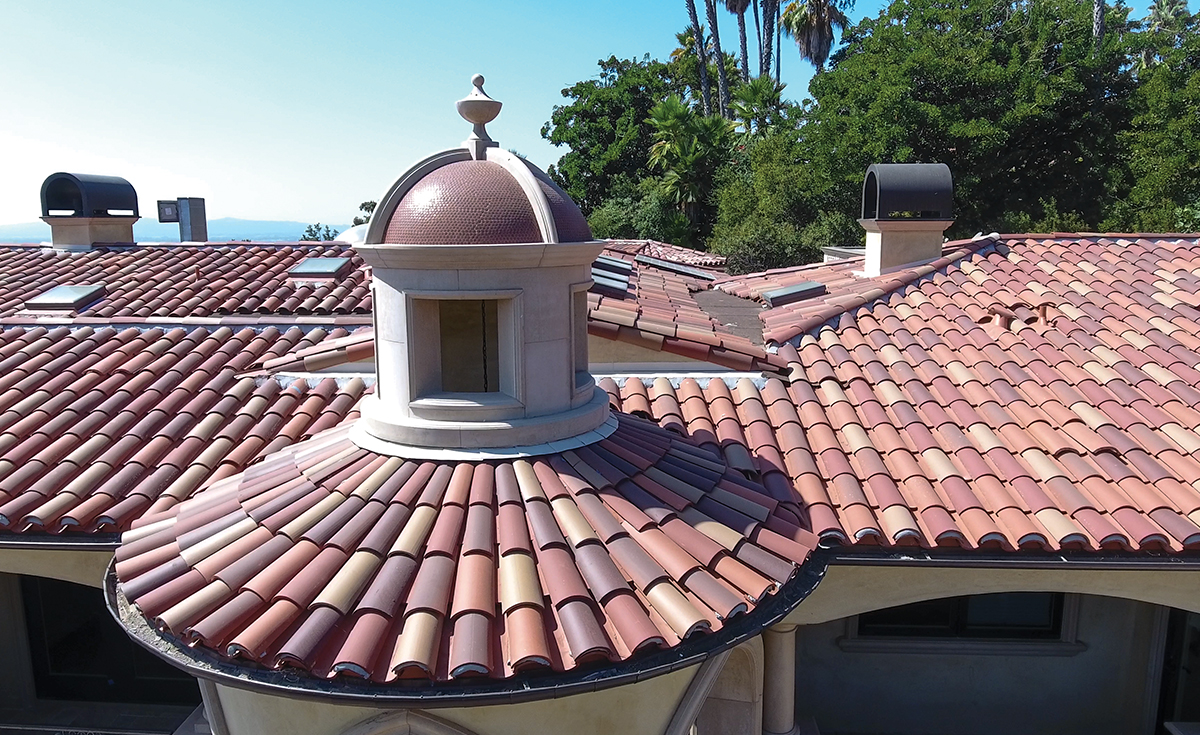 Close up view of front turret and roof on custom mansion on a hilltop in Bradbury California featuring Classic Tapered two piece terra-cotta clay roof tile with turrets, domes, and dome awnings in custom color blend CB477.