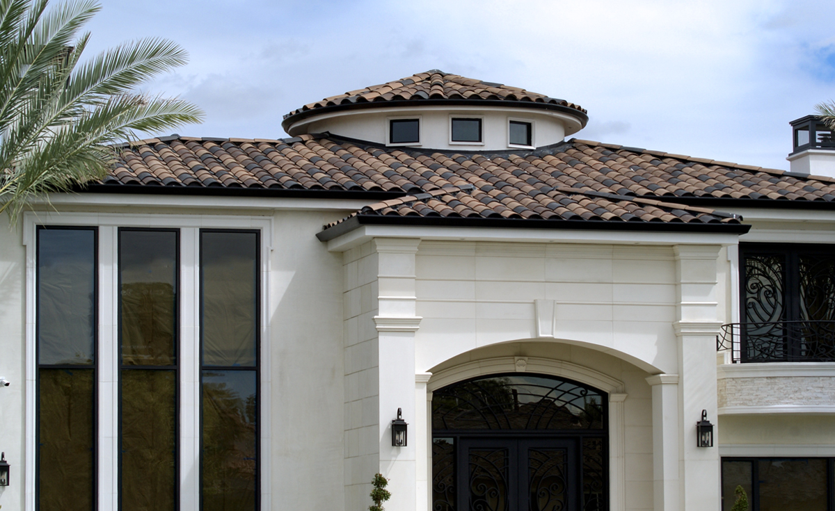 Detail of custom home in Downey, CA featuring One Piece S Mission Spanish style clay roof tile in 80% B317-R Taupe Smoke Blend, 20% 2F51-R Adobe Black Pebbled with 100% 2F51 Adobe Black birdstop